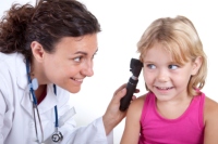 Medical practitioner, other CAST team member, and a child pictured in an examination room. Children pictured are child actors