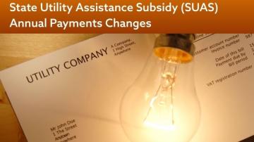 A lightbulb sits atop utility bills with the words "State Utility Assistance Subsidy (SAUS) Annual Payment Changes" at the top. 