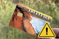 Photo of a California Electronic Benefit Transfer Card with a caution sign 